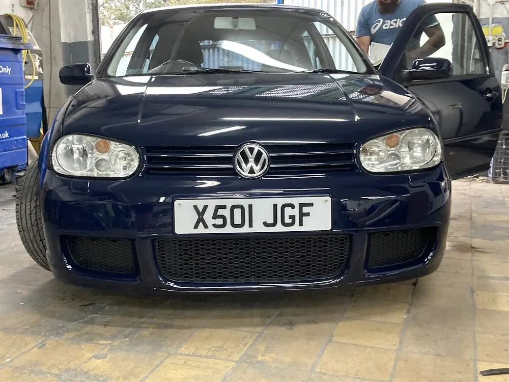 A navy Volkswagen Golf in the workshop
